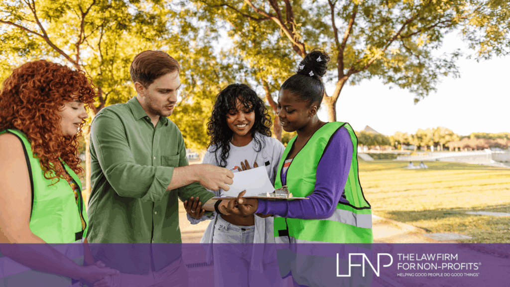 Volunteers meeting in a park reviewing documents together, supported by The Law Firm for Non-Profits.